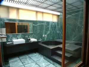 a bathroom with a tub and a sink and a mirror at Boutique Hot Spring Resort in Xindian