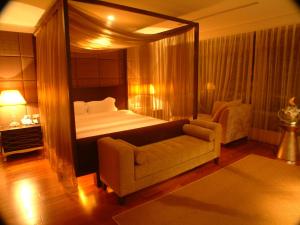 - une chambre avec un lit à baldaquin et un canapé dans l'établissement Boutique Hot Spring Resort, à Xindian