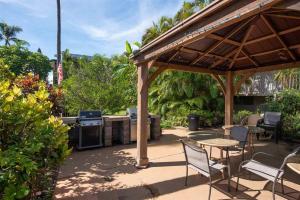 un patio con mesa, sillas y parrilla en Maui Tranquility II en Kihei