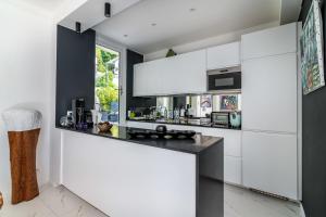 a kitchen with white cabinets and a counter at Appartement Mera Cosy apartment with incredible sea view in Èze