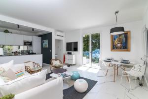a white living room with a white couch and a table at Appartement Mera Cosy apartment with incredible sea view in Èze