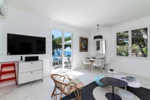 a living room with a television and a table and chairs at Appartement Mera Cosy apartment with incredible sea view in Éze