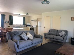 ein Wohnzimmer mit einem Sofa und einem Stuhl in der Unterkunft Alexandra Garden Court Motel in Alexandra