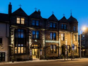 a large building with a clock on the front of it at Kinnettles Hotel & Spa in St Andrews