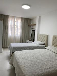 a bedroom with two beds and a window at Apartamento Copacabana - Quadra da Praia in Rio de Janeiro