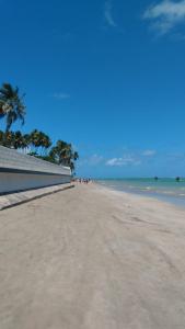 a sandy beach with palm trees and the ocean at casa morada da praia in Xeréu