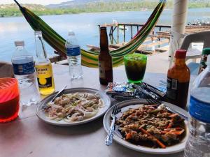 uma mesa com dois pratos de comida e garrafas de cerveja em Club Cadena em Acapulco