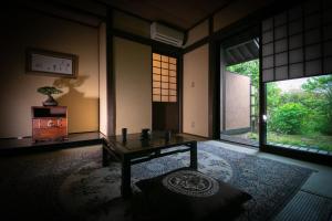 Habitación con mesa en una habitación con ventanas en Yufuin Kaze no Mori, en Yufu