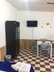 a room with a table and a tv on the wall at Apartamento Mattos in Taganga