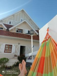 een persoon die voor een huis staat met een hark bij La posada del Nono in Villa Gesell