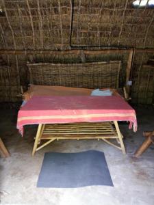 a bed in a straw hut with a pink blanket at Room in BB - Mida Creek Eco Camp - lodge 