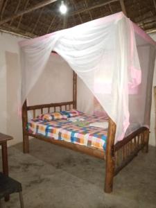 a bed with a mosquito net on top of it at Room in BB - Mida Creek Eco Camp community project,Mida Creek Watamu Kilifi County 