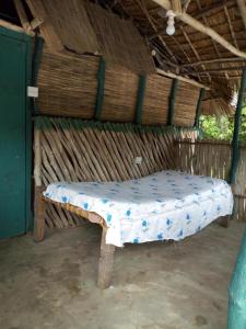 een bed in een strohut met een matras bij Room in BB - Mida Creek Eco Camp - cosy lodge 