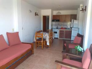 een woonkamer met een bank en een keuken bij La posada del Nono in Villa Gesell +26 foto's