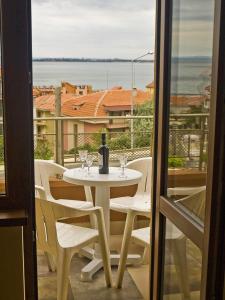 Biały stół z butelką wina na balkonie w obiekcie Villa ani Sveti Vlas Bulgarian Black Sea Coast Open may to october w Swetim Własie