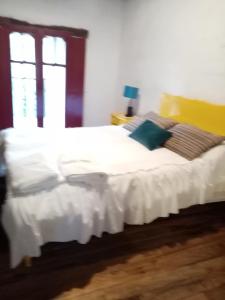 a bedroom with a white bed with a window at Estancia El Sol in Sogamoso