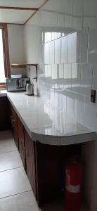 a kitchen with a white counter top in a room at Cabañas Emporio de la Meme in San José de Maipo