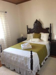 a bedroom with a large bed with a wooden headboard at Casa do Avô Silva in Santa Cruz das Flores