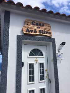- un bâtiment blanc avec une porte et un panneau au-dessus dans l'établissement Casa do Avô Silva, à Santa Cruz das Flores