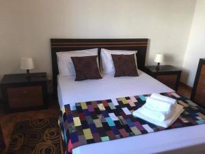 łóżko z kolorowym kocem i poduszkami w obiekcie Casa do Avô Silva w mieście Santa Cruz das Flores