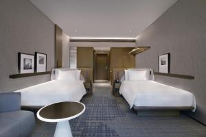 een hotelkamer met 2 bedden en een bank bij Crowne Plaza Shenzhen World Exhibition and Convention Center, an IHG Hotel in Shenzhen