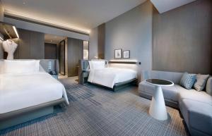 um quarto de hotel com duas camas e um sofá em Crowne Plaza Shenzhen World Exhibition and Convention Center, an IHG Hotel em Shenzhen