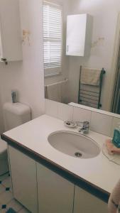 a white bathroom with a sink and a toilet at Mandurah Riverfront Holiday Rental in North Yunderup