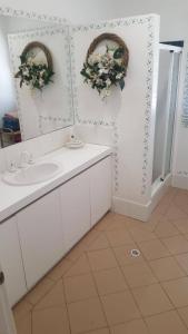 a bathroom with a sink and two wreaths on the wall at Mandurah Riverfront Holiday Rental in North Yunderup