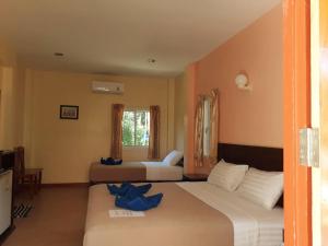 ein Schlafzimmer mit zwei Betten mit blauen Bogen in der Unterkunft Boonya Resort Koh Chang in Ko Chang