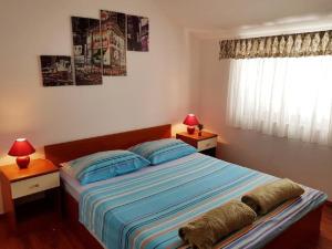 a bedroom with a bed with two lamps and a window at Apartments Mila - 2 bedrooms and free parking in Makarska