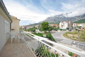 a balcony with a table and chairs and a mountain at Apartments Mila - 2 bedrooms and free parking in Makarska