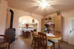 a kitchen and dining room with a table and a stove at Csermely Panzio in Izvoru Mureşului