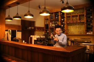 a man standing behind a bar in a restaurant at Hotel Middle Path & Spa in Pokhara