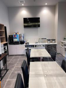 a kitchen with a table and chairs and a television at Remington Hotel in Akashi