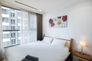 - une chambre avec un lit blanc et une fenêtre dans l'établissement BOM HOMES- Vinhomes Times City- Service Apartment, à Hanoï