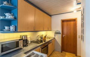 une cuisine avec des armoires en bois et un évier dans l'établissement Beautiful Apartment In Friedrichskoog, à Friedrichskoog