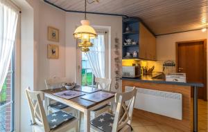 cocina y comedor con mesa y sillas en Cozy Apartment In Friedrichskoog With Kitchen, en Friedrichskoog