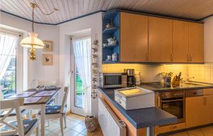 une cuisine avec des armoires en bois et une table avec un comptoir dans l'établissement Beautiful Apartment In Friedrichskoog, à Friedrichskoog