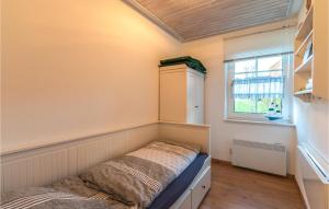 Habitación pequeña con cama y ventana en Cozy Apartment In Friedrichskoog With Kitchen, en Friedrichskoog