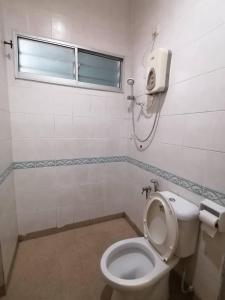 a bathroom with a white toilet and a window at S2 Hotel in Seremban