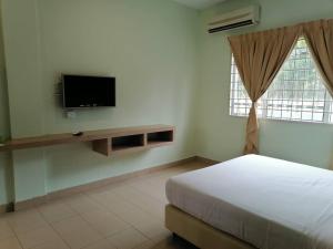 a bedroom with a bed and a tv on the wall at S2 Hotel in Seremban