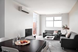 a living room with a table with fruit on it at Punthill Williamstown in Williamstown