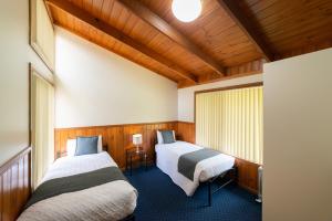 霍尔斯加普Halls Gap Valley Lodges的一间木墙房间里有两张床