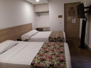 En eller flere senger på et rom på Hotel Poma Rosa