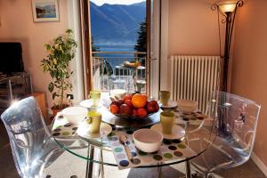 una mesa de cristal con un bol de fruta. en Casa Giallo, en Lenno