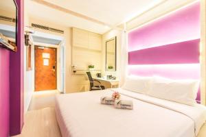 1 dormitorio con 1 cama blanca grande con 2 cajas en Fragrance Hotel - Viva, en Singapur