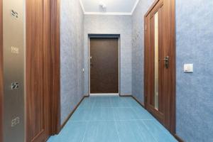 einen Flur mit Tür und blauem Boden in der Unterkunft Современные апартаменты метро Харьковская in Kiew