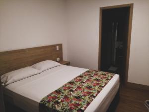 En eller flere senger på et rom på Hotel Poma Rosa