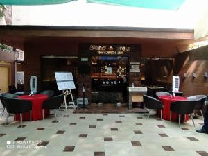 a restaurant with red tables and chairs and a bar at Hotel Plaza in Mumbai