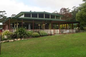 a large house with a green roof and a yard at Halls Gap Valley Lodges in Halls Gap
